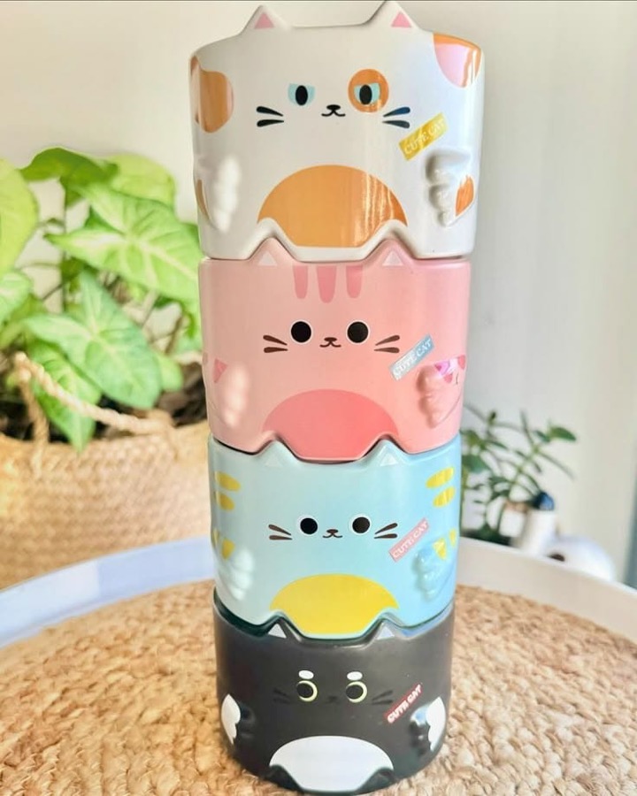 Stack of four cat-face ceramic mugs in white, pink, blue and black